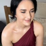 Woman wearing burgundy dress posing indoors