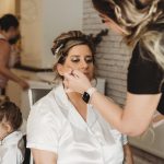 Bride having makeup applied on wedding morning